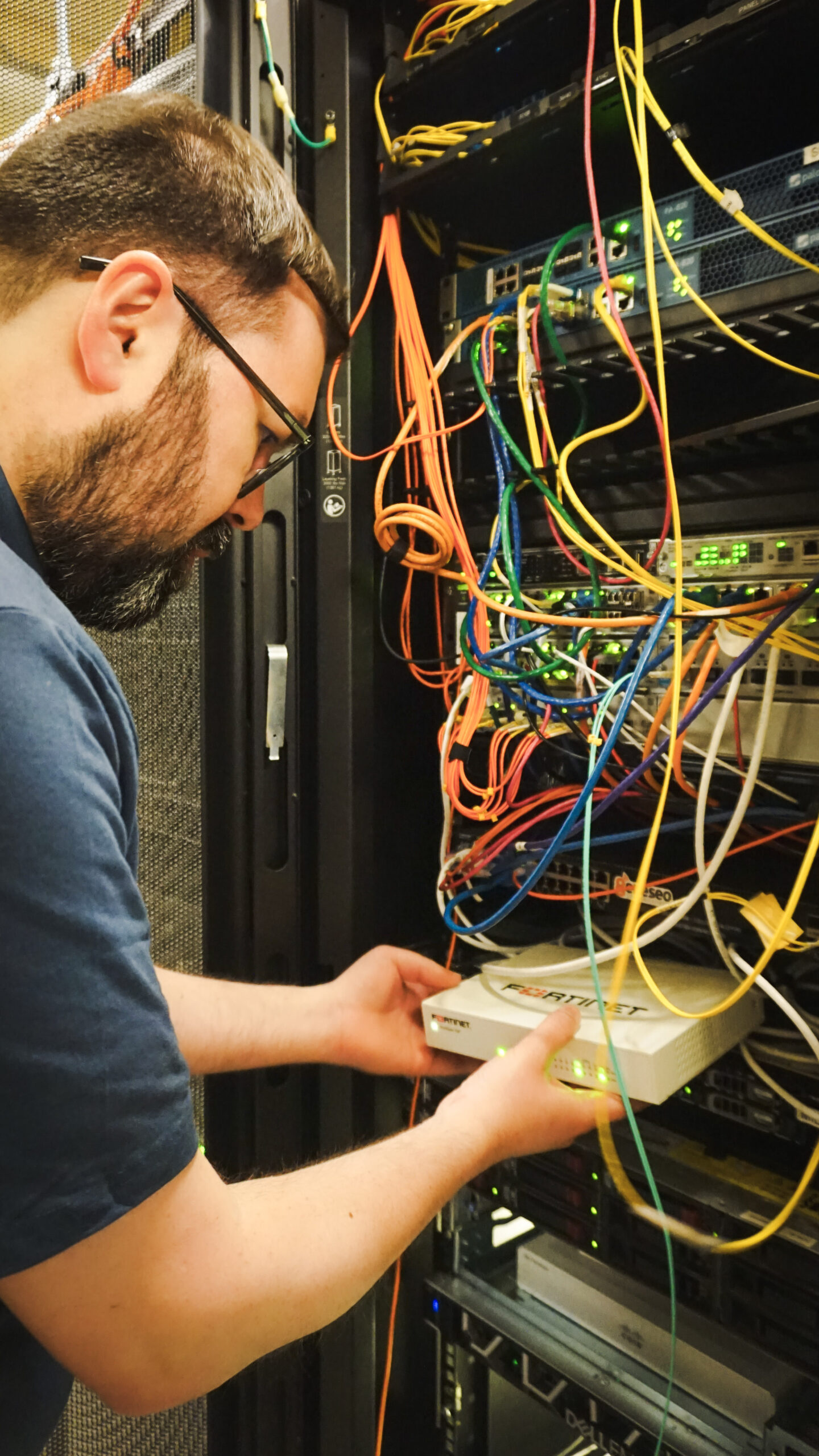 Man with beard looking at a fortinet box