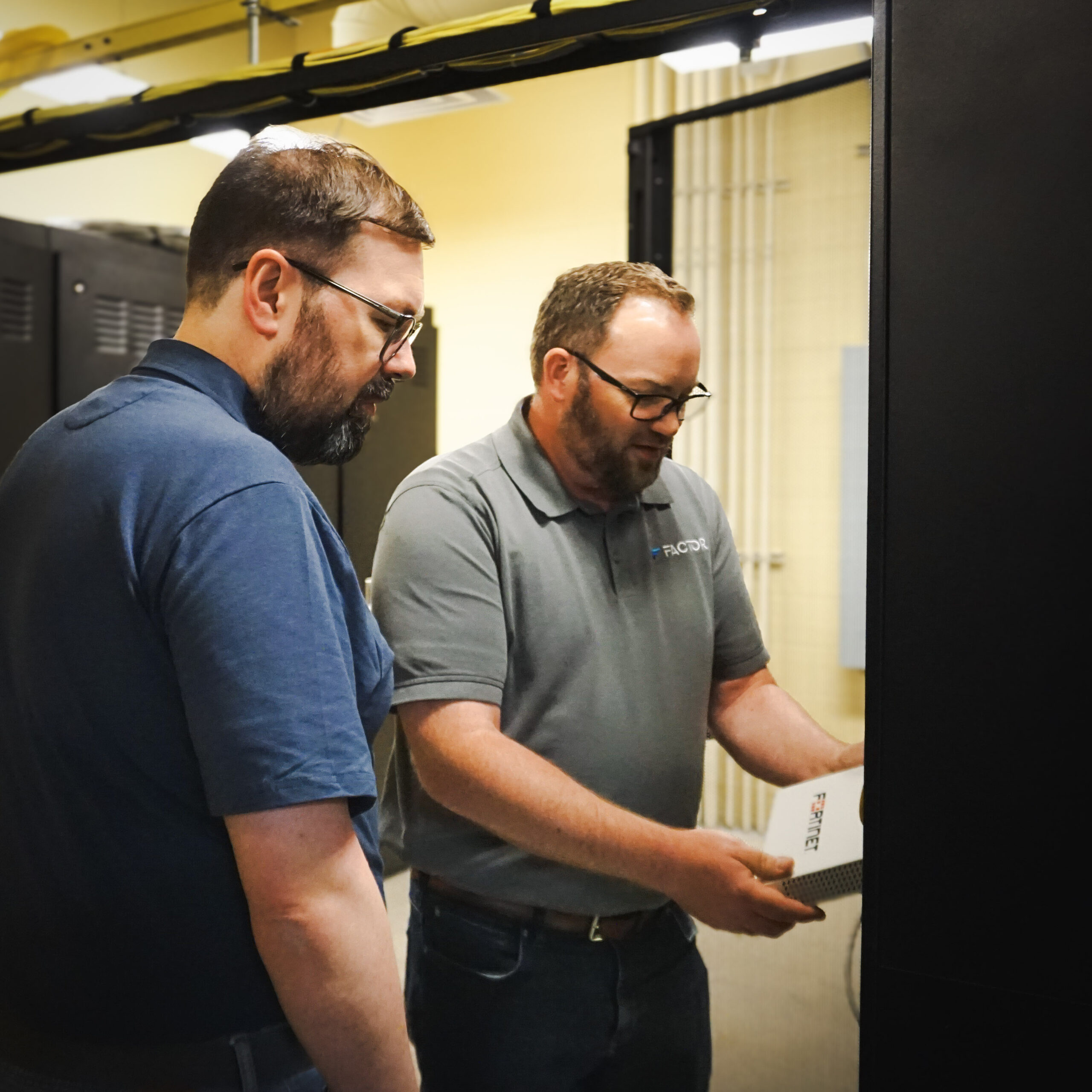 Two guys looking at a computer box